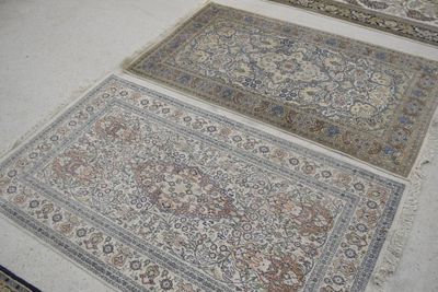 Plusieurs tapis orientaux sont disposés sur le sol dans une pièce