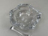 a glass ashtray and a spoon on a table