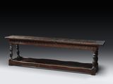 un vieux banc en bois posé sur un sol gris
