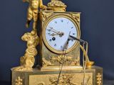 une horloge en or surmontée d'une statue