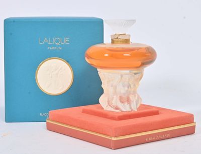 une image représentant un flacon de parfum posé sur une boîte