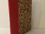 un livre posé sur une table, avec une couverture rouge