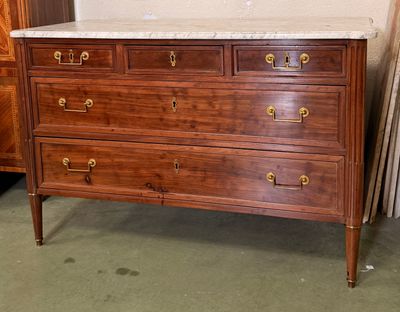 une commode en bois avec un plateau en marbre dans une pièce