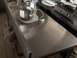 a large kitchen with a stainless steel counter and a mixer on the island