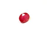 gros plan d'une pierre de rubis rouge sur une surface blanche