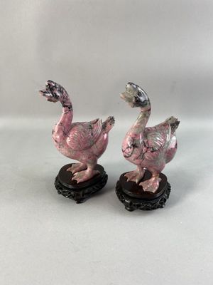 paire de canards en céramique roses et blancs sur des socles noirs