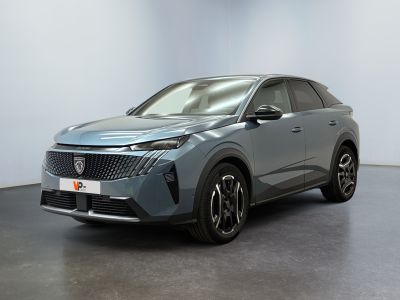 Une voiture grise est garée dans une pièce aux murs blancs.