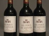 three bottles of red wine are lined up on a table