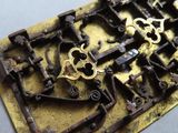 a lot of old keys that are laying on a piece of metal
