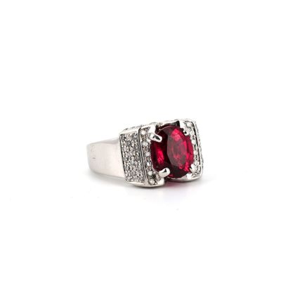 gros plan d'une bague avec une pierre rouge entourée de diamants