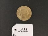 a gold coin on a black surface with a price tag