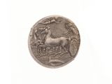 une pièce d'argent sur laquelle figurent un cheval et une calèche