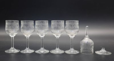 plusieurs verres à vin vides et une bouteille de vin posés sur une table