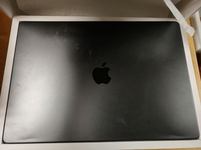 une boîte ouverte, ornée d'un logo en forme de pomme, posée sur une table