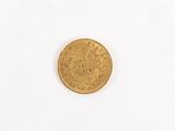 a gold coin on a white surface with a white background