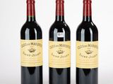 trois bouteilles de vin rouge posées l'une à côté de l'autre sur une surface blanche