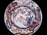a plate with a bird on it on a black background