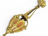 une broche ancienne aux couleurs or et corail sur fond blanc