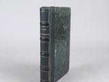 an old book sitting on top of a table next to a white wall