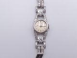an image of a woman ' s wrist watch with a chain around it