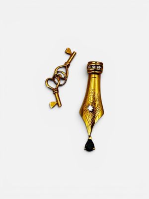 a close up of a pen and a key on a white surface
