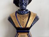 a blue and gold bust of a man with a hat on