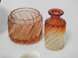 three different colored glass vases on a white table