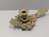 a close up of a brass candle holder on a white surface