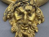 a gold clock with a face on the front of it