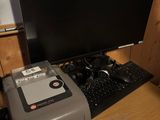 un ordinateur et une imprimante posés sur un bureau dans une pièce
