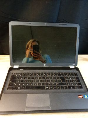 un ordinateur portable posé sur une table, avec une personne en train de le prendre en photo