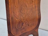 a wooden clock on a stand on a white surface