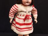 a doll that is wearing a red and white striped dress and hat
