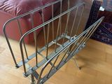 a metal magazine rack on the floor in a living room