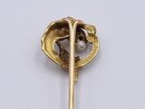 a gold brooch with a pearl in the middle