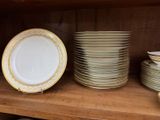 many plates and bowls on a shelf in a cabinet