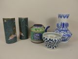 trois vases, une théière et un pot à thé posés sur une table