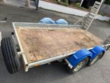 a trailer with a flat bed on the side of the road
