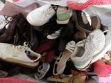 many pairs of shoes that are piled together on a bed