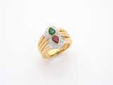 un gros plan d'une bague en or sertie d'une pierre verte et rouge