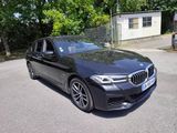 the bmw 5 series sedan is parked on the side of the road