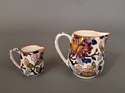 two pieces of pottery sitting on top of a table next to each other