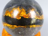 a close up of a black marble ball on a wooden stand