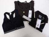 a close up of three black sports bra tops on a white table