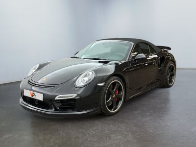 the black porsche 911 gts is parked in a large room