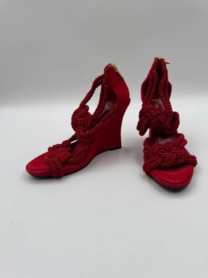 une paire de chaussures à talons compensés rouges ornées d'un nœud au niveau de la pointe
