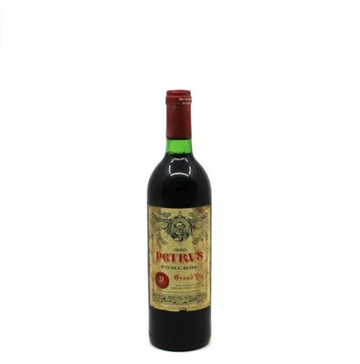 a bottle of red wine sitting on top of a white table