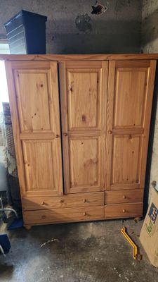 une photo d'une armoire en bois au milieu d'une pièce