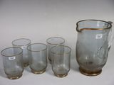 five glasses and a pitcher sitting on a table