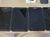 three black iphones are sitting on a table next to a box